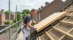 Dakwerker plaatst isolatieplaten onder dakpannen van een hellend dak