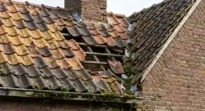 # Alt-tekst voor dakafbeelding Beschadigd Nederlands dak met gebroken en verschoven rode dakpannen, gaten in het